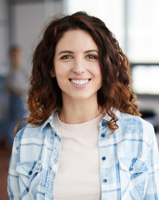 cheerful-young-woman-posing-in-creative-agency-P8NMKLX.jpg