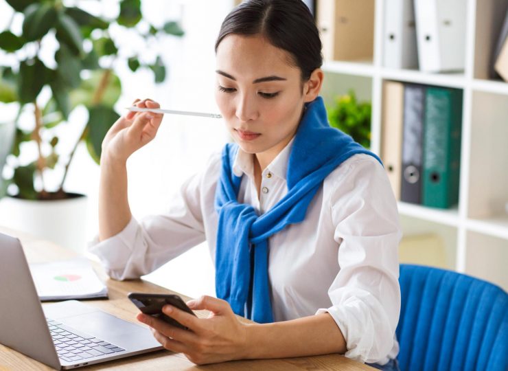 image-of-asian-woman-using-laptop-and-cellphone-wh-KAFYTVB.jpg